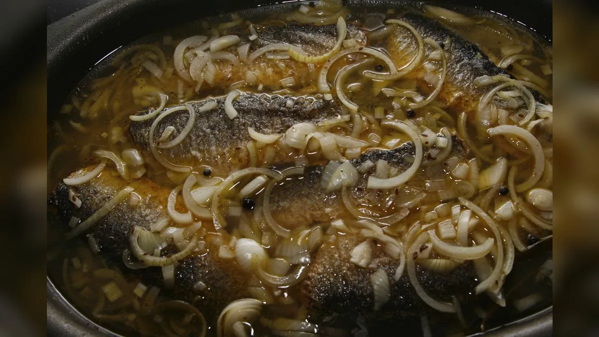 Gebratene Fischfilets in einer Marinade aus Essig, Zwiebelringen und Pfefferkörnern