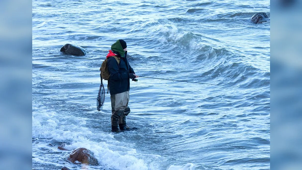 Angler beim Wurfangeln in der Brandung, ständig in Bewegung entlang des Ufers